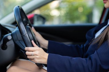 Gündelik kıyafet içinde çekici genç bir kadın sürücü, sürücü arabası, yol güvenliği ve ulaşım teması. Araba kullanan genç bir kadın. Seyahat kavramı.