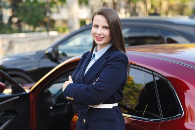 Gündelik kıyafet içinde çekici genç bir kadın sürücü, sürücü arabası, yol güvenliği ve ulaşım teması. Araba kullanan genç bir kadın. Seyahat kavramı.