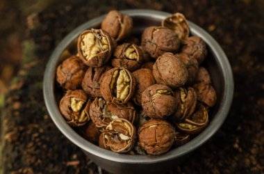 Ceviz kabuğu soyulmuş çekirdekler ve ahşap arka planda cevizler. Sağlıklı fındık yemeği. Makro. Kırık kabuklar.