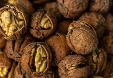 Ceviz kabuğu soyulmuş çekirdekler ve ahşap arka planda cevizler. Sağlıklı fındık yemeği. Makro. Kırık kabuklar.