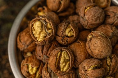 Ceviz kabuğu soyulmuş çekirdekler ve ahşap arka planda cevizler. Sağlıklı fındık yemeği. Makro. Kırık kabuklar.