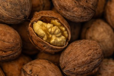 Ceviz kabuğu soyulmuş çekirdekler ve ahşap arka planda cevizler. Sağlıklı fındık yemeği. Makro. Kırık kabuklar.