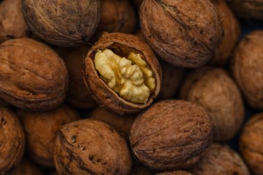 Ceviz kabuğu soyulmuş çekirdekler ve ahşap arka planda cevizler. Sağlıklı fındık yemeği. Makro. Kırık kabuklar.