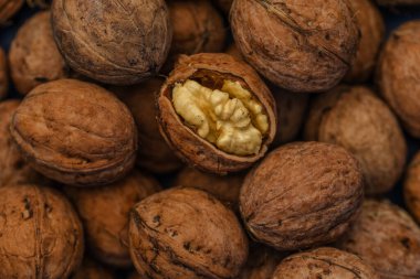 Ceviz kabuğu soyulmuş çekirdekler ve ahşap arka planda cevizler. Sağlıklı fındık yemeği. Makro. Kırık kabuklar.