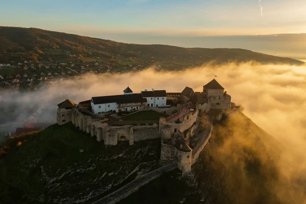 Aerial view about castle of Sumeg with foggy sunrise at the background.