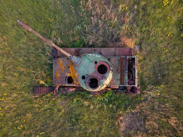 農業分野の真ん中に放棄された錆びた戦車についての空中視界を閉じる — ストック写真