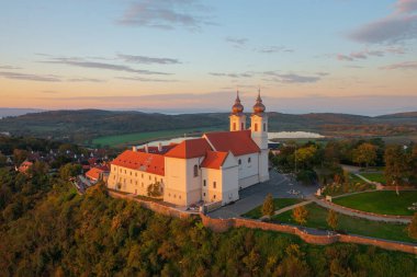 Tihany, Hungary - Aerial skyline view about the famous Benedictine Monastery of Tihany (Tihany Abbey) with beautiful colourful sky and clouds at sunrise. clipart