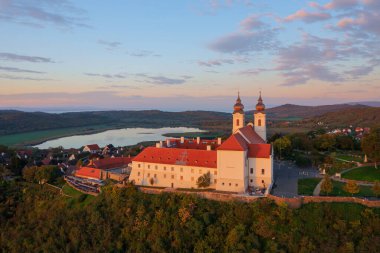 Tihany, Hungary - Aerial skyline view about the famous Benedictine Monastery of Tihany (Tihany Abbey) with beautiful colourful sky and clouds at sunrise. clipart