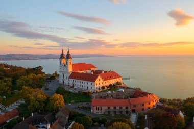 Tihany, Hungary - Aerial skyline view about the famous Benedictine Monastery of Tihany (Tihany Abbey) with beautiful colourful sky and clouds at sunrise. clipart