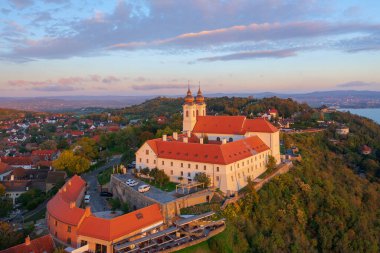 Tihany, Hungary - Aerial skyline view about the famous Benedictine Monastery of Tihany (Tihany Abbey) with beautiful colourful sky and clouds at sunrise. clipart