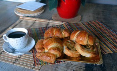 Çeşitli geleneksel Fransız kruvasanlarıyla kahvaltı, çikolatalı ekmek, rustik üzümlü üzüm taze pişmiş kruvasan ve beyaz çikolatalı kek.. 
