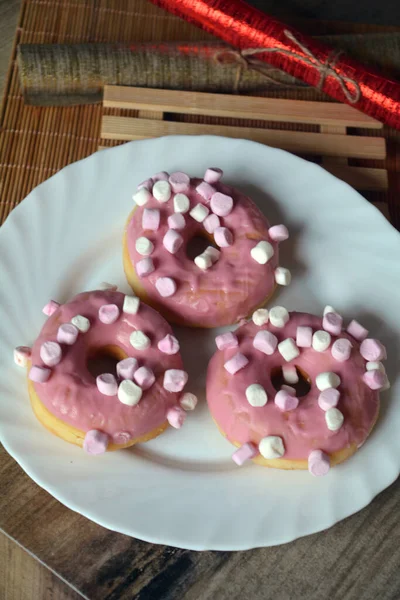 Три Пончика Розовой Глазурью Тарелке Деревянном Столе Сладкий Завтрак — стоковое фото