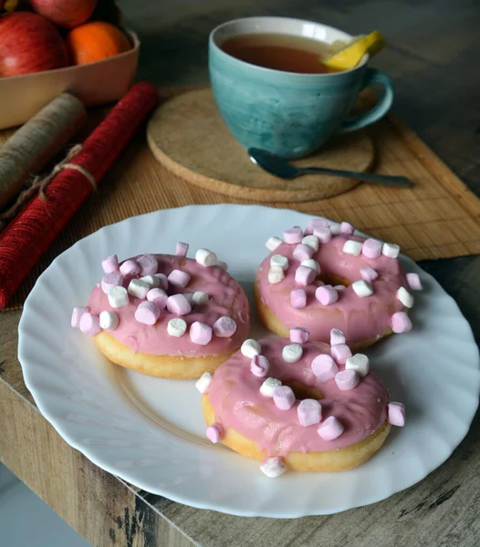 Чашка Черного Чая Лимоном Три Пончика Розовой Глазурью Тарелке Деревянном — стоковое фото