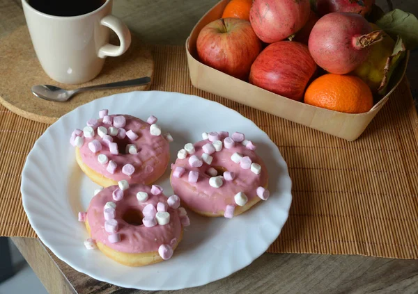 一杯咖啡加牛奶和三个甜甜圈加粉红糖衣在白盘上甜早餐 — 图库照片