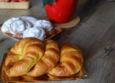 Tabakta üç tane taze kruvasanla kahvaltı..