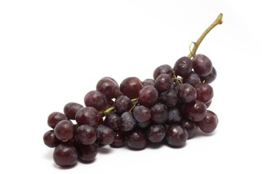 Taze organik kırmızı üzümler beyaz arka planda izole edilmiş lezzetli meyve tarafı manzarası.