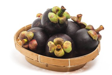 Beyaz arka planda izole edilmiş bambu sepeti içinde taze organik mangosteen lezzetli meyveler.