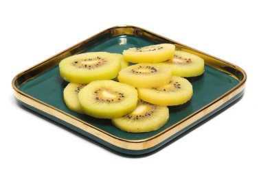 Dilimlenmiş taze organik altın kivi grubu. Beyaz arka planda izole edilmiş yeşil bir tabakta lezzetli meyveler.