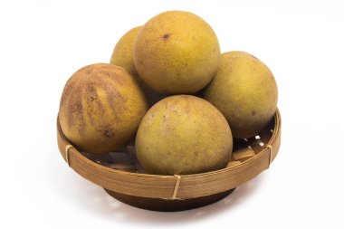 Bir grup taze organik sapodilla beyaz arka planda izole edilmiş bambu sepet tabakta lezzetli meyveler.