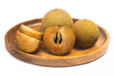 Yarısı kesilmiş ve iki taze organik sapodilla lezzetli meyveler beyaz arka planda izole edilmiş bir tabakta.