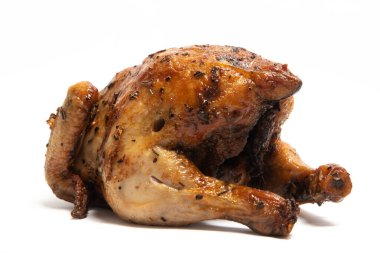 Beyaz arka planda izole edilmiş otlarla tatlandırılmış leziz bir kızarmış tavuk.