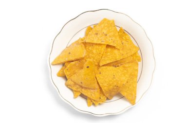 Beyaz arka planda izole edilmiş küçük beyaz bir tabakta çıtır mısır cipsi cipsi cipsi.