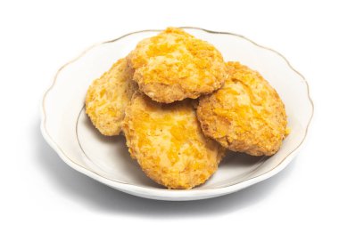 Beyaz arkaplan kırpma yolunda izole edilmiş küçük beyaz bir tabakta mısır gevreği kurabiyeleri