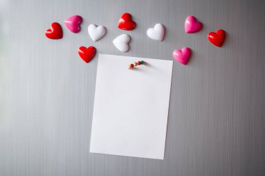 Abstract of wooden heart clip with Blank paper and stick paper on refrigerator door. paper note copy space for add text. valentine picture message background