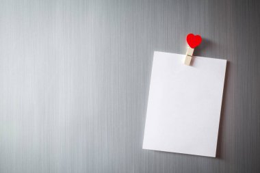 Abstract of wooden heart clip with Blank paper and stick paper on refrigerator door. paper note copy space for add text. valentine picture message background