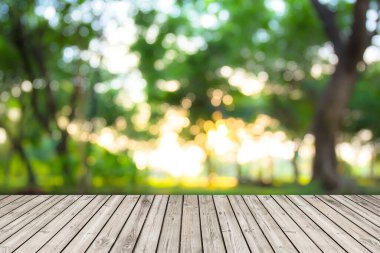 Abstract Natural wood table with Morning sunlight blur tree background : Top view of plank wood for graphic stand product, interior design or montage display your product