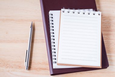 White note paper notebook open pages with pencil on wooden table. picture used for add text or education message.