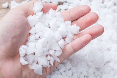 abstract Sea salt in man hand on a wood table