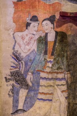 NAN, THAILAND - April 15, 2015: Mural painting of a man whispering to the ear of a woman at Wat Phumin in Nan Province, Northern Thailand.