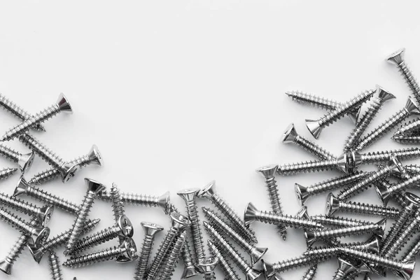 screws, stainless nuts and bolts on grunge metal background. top view Picture space for text message, flat lay Banner for website.