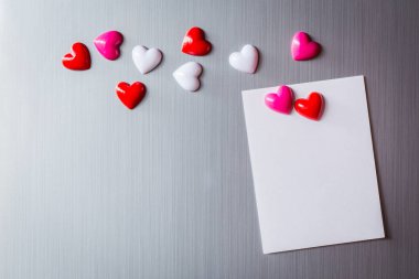 Abstract of wooden heart clip with Blank paper and stick paper on refrigerator door. paper note copy space for add text. valentine picture message background