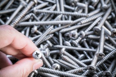 Yapışkan madde için insan elinin üzerine metal vida. Ev inşaatı için elektrikli matkap. Endüstriyel aksesuar.