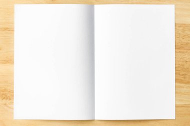 Tahta masanın üzerinde beyaz not defteri açık sayfalar.