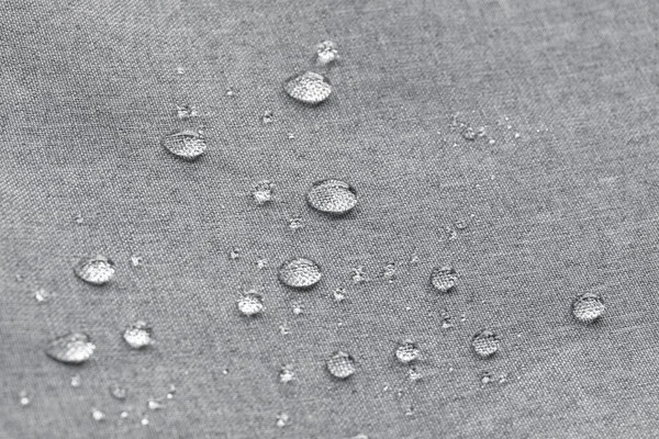 Waterproof droplets on fabric. Grey Canvas Polyester texture synthetical for background. Black polyester textile backdrop for interior art design or add text message.