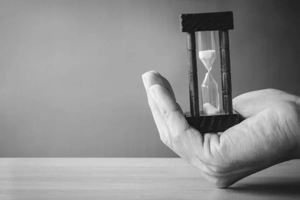 Concept image of management at the time of life. Abstract hourglass on man hand. passing time in a countdown sandglass with copy space for add text.