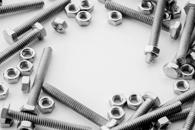 Beyaz arka planda vidalar, paslanmaz fındıklar ve cıvatalar. Metin iletisi için üst görünüm Resim alanı, web sitesi için düz konum flaması.