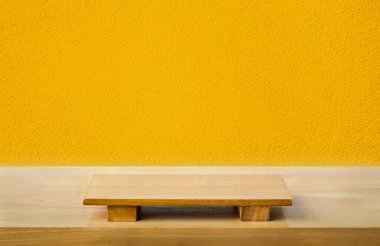 Ahşap masanın üzerinde sarı çimento desenli boş suşi tahtası. Grafik standı ürünü, iç tasarım veya montaj için tahtanın üst görünümü ürününüzü gösterir.