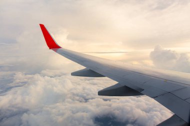 Bir uçağın kanadıyla gün doğumu. Fotoğraf turizm operatörlerine ve hızlı ve verimli ulaşım araçlarına uygulandı. Mesaj ya da resim çerçevesi web sitesi eklemek için resim. Seyahat kavramı.