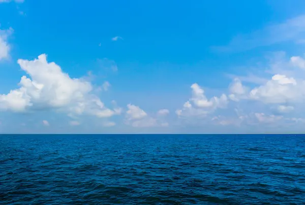 Derin Mavi deniz ve açık gökyüzü bulutlarıyla su yüzeyinde. Okyanus manzarası, küçük dalgalar, su yansıması. Turizm, web sitesi veya reklam için resim. Andaman Denizi, Tayland.