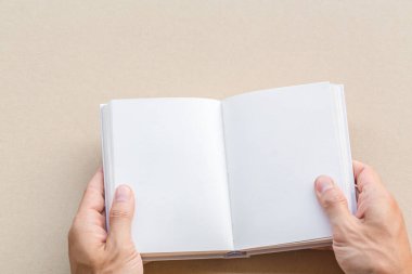 Elleri boş tutulan bir adam, beyaz sayfalarla açılmış bir kitap taklidi yapar. Ders kitabı ya da şablon çalışması tasarım defteri eklemek için boş kağıt sayfa.