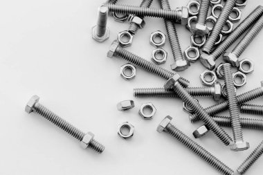 Beyaz arka planda vidalar, paslanmaz fındıklar ve cıvatalar. Metin iletisi için üst görünüm Resim alanı, web sitesi için düz konum flaması.