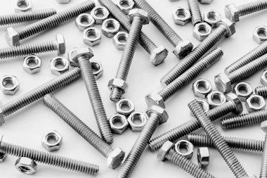 Beyaz arka planda vidalar, paslanmaz fındıklar ve cıvatalar. Metin iletisi için üst görünüm Resim alanı, web sitesi için düz konum flaması.