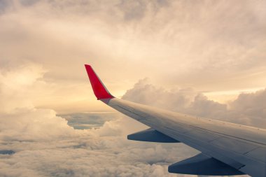 Bir uçağın kanadıyla gün doğumu. Fotoğraf turizm operatörlerine ve hızlı ve verimli ulaşım araçlarına uygulandı. Mesaj ya da resim çerçevesi web sitesi eklemek için resim. Seyahat kavramı.