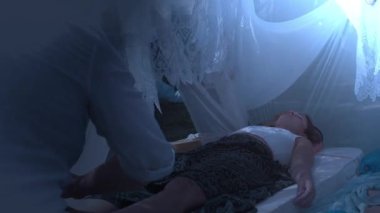 male masseur massages the legs in a beautiful white ornamrental tent