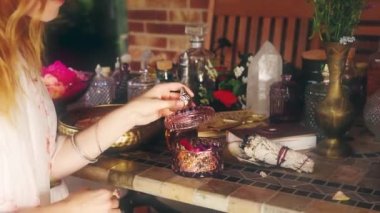 Gerekli yağı hazırlamak için gül çiçeği. Spa ve aromaterapi. Kadın gül yaprakları gibi kokuyor. Adaçayı tütsülü arka plan, tören alanı
