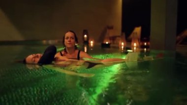 Havuzda terapi egzersizi. Havuzda su terapisi gören bir kadın. Su rahatlaması ve derin meditasyon